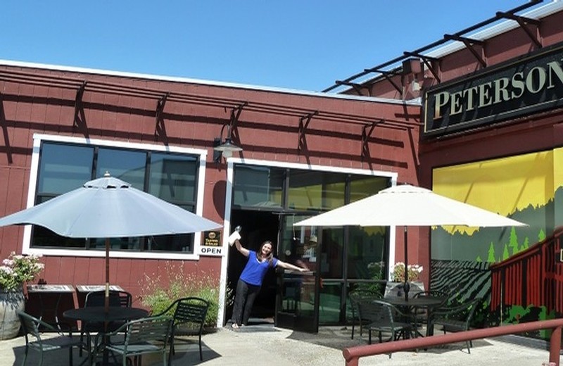 A view of our tasting room patio with umbrella-shaded seating and welcoming tasting room staff