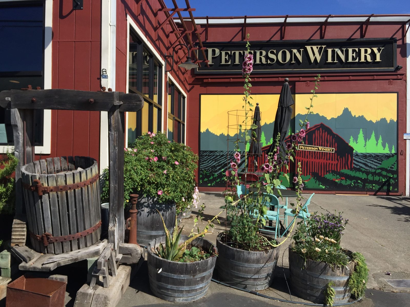 Exterior of the Peterson Winery tasting room featuring the Peterson mural and red-barn logo.